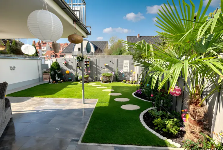 Gepflegter Privatgarten mit Rasen, Beeten und Dekoration – Beispiel für professionelle Gartenpflege durch HashTEC für Privatkunden.
