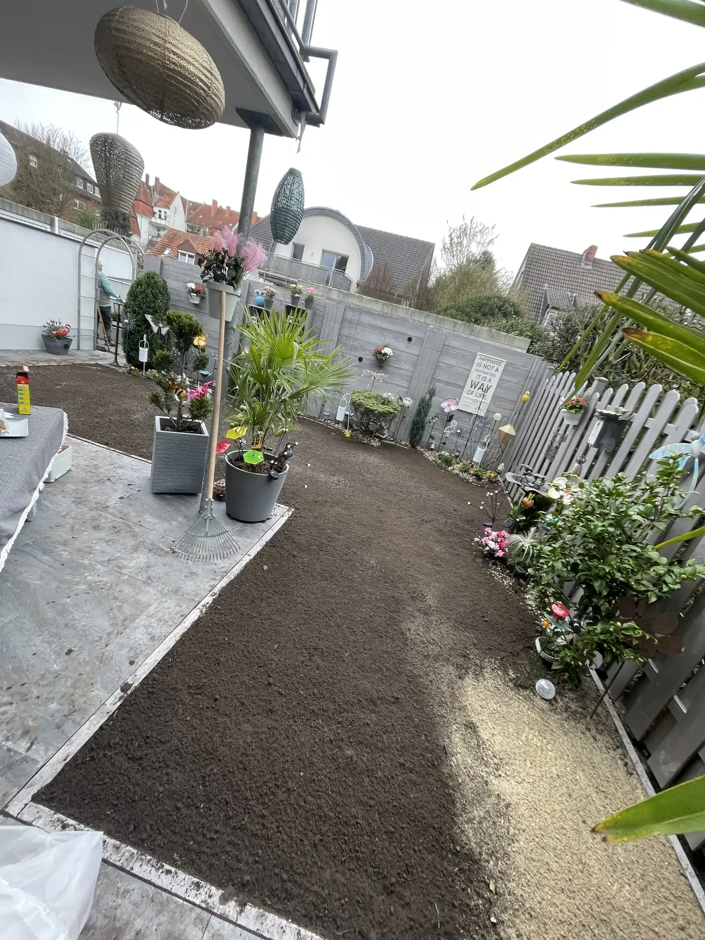 Ungepflegter Innenhof mit Erde und Pflanzen in Töpfen, bereit für professionelle Garten- und Grauflächenpflege durch HashTEC.